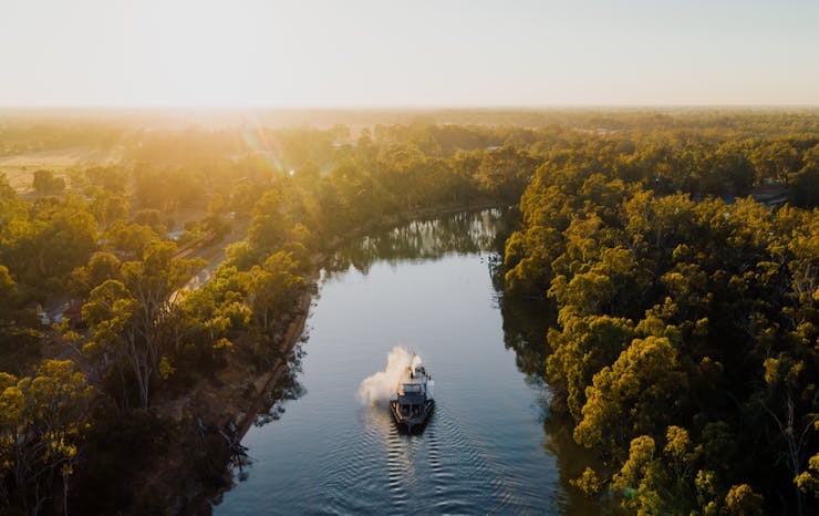 A boat going down the Murray River in Echuca with the sun shining. 