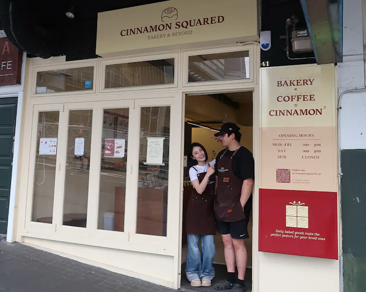 Ellie and Minseok Lee stand in the doorway of Cinnamon Squared. 