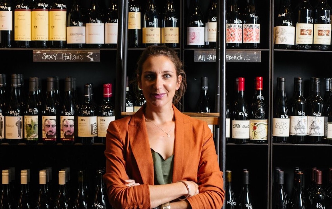 Emma Farrelly standing in front of shelves filled with wine