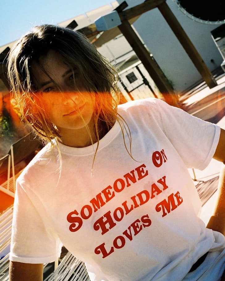 A woman wears a slogan t-shirt from Emma Mulholland On Holiday one of the best Australian fashion labels