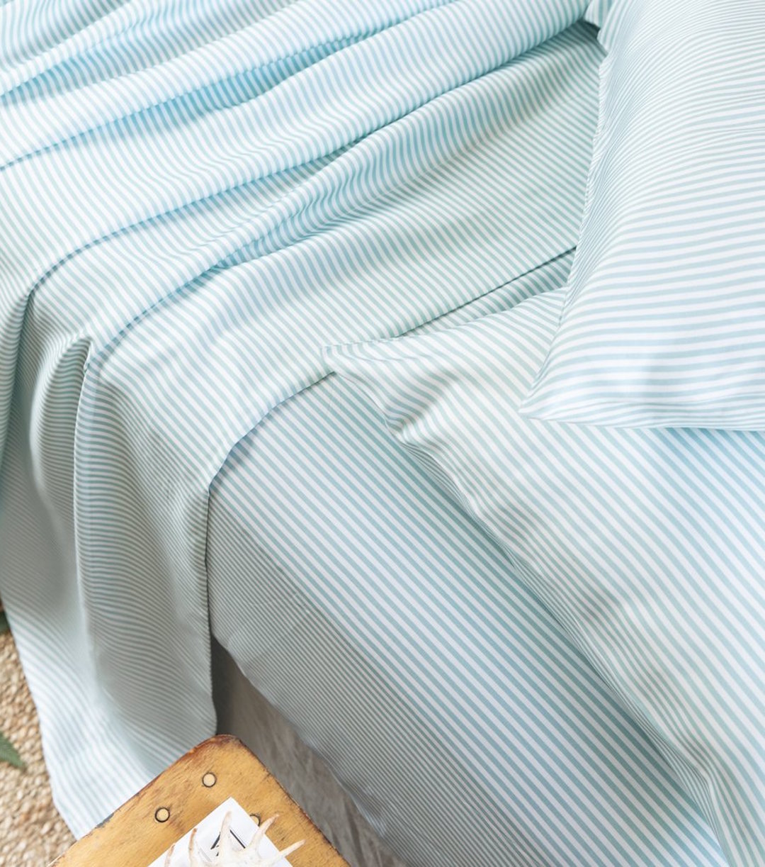 Messy blue and white sheets sit on a bed. 
