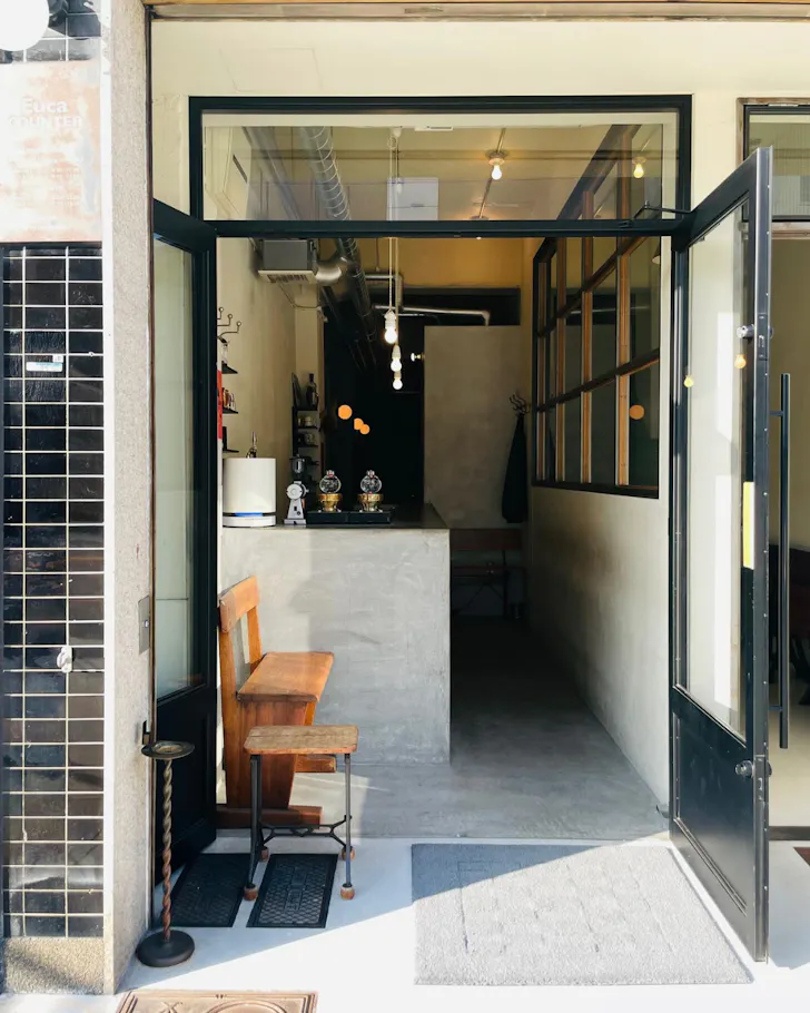 The unassuming, sunlit facade of Euca Counter cafe during the day, Osaka.