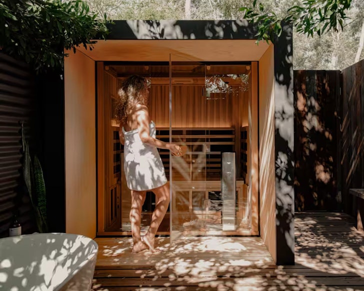 A woman enters the sauna at Explorer's Rest Airbnb one of the best romantic getaways in Australia