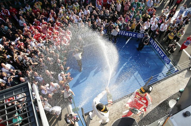 A F1 podium with people spraying champagne. 