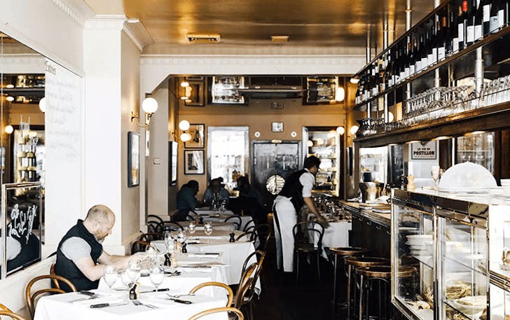 A white-painted diner with mirrored walls at one of the best late-night restaurants Melbourne.