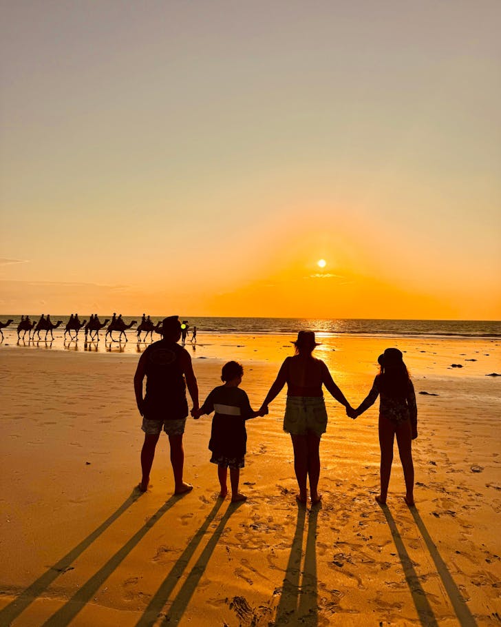 Family sunset with beach camels.