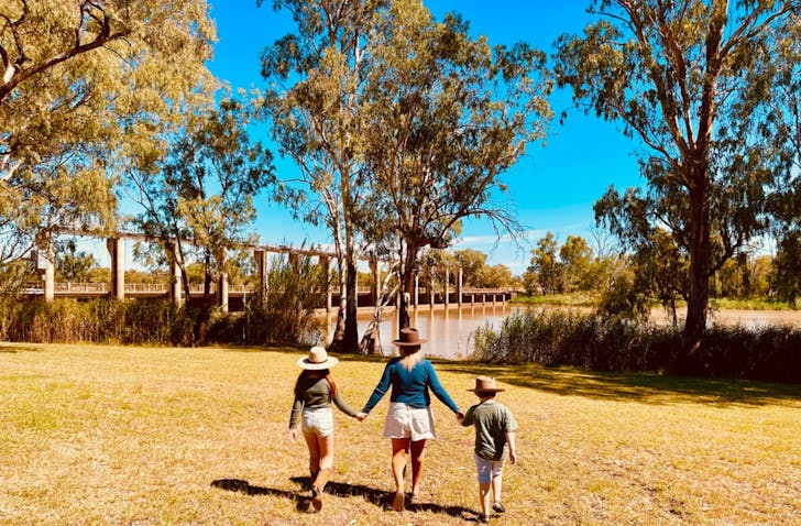 Family walking near riverside bridge