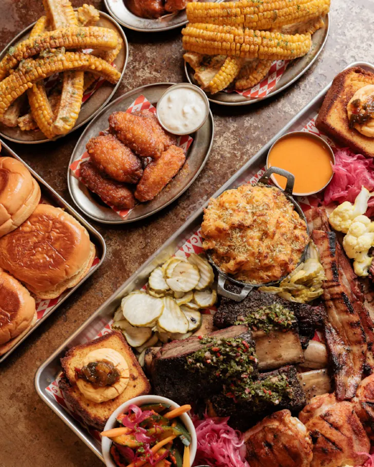 A table full of BBQ goods from Fancy Hank's including corn, brisket and burgers