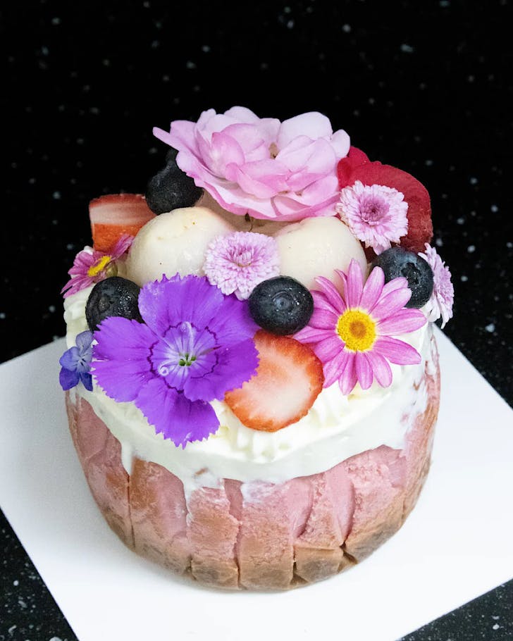 A flower-topped lychee strawberry Valentines cake.
