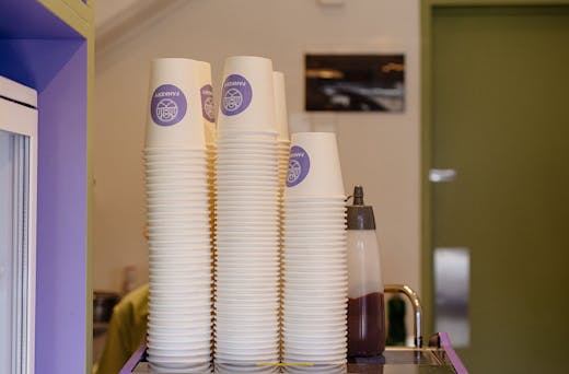 Cups stacked high on a coffee machine. 