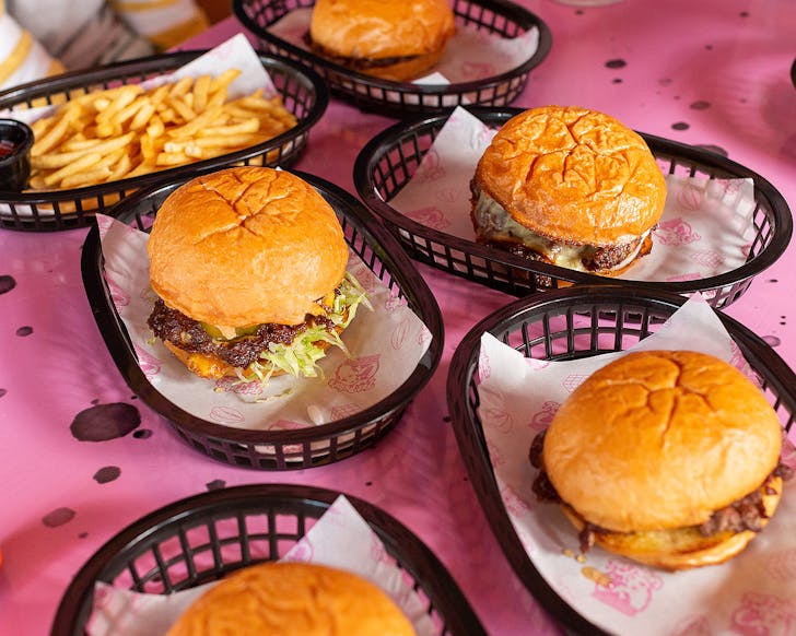 A collection of burgers on the table at Fat Puku's Smashed Burgers.