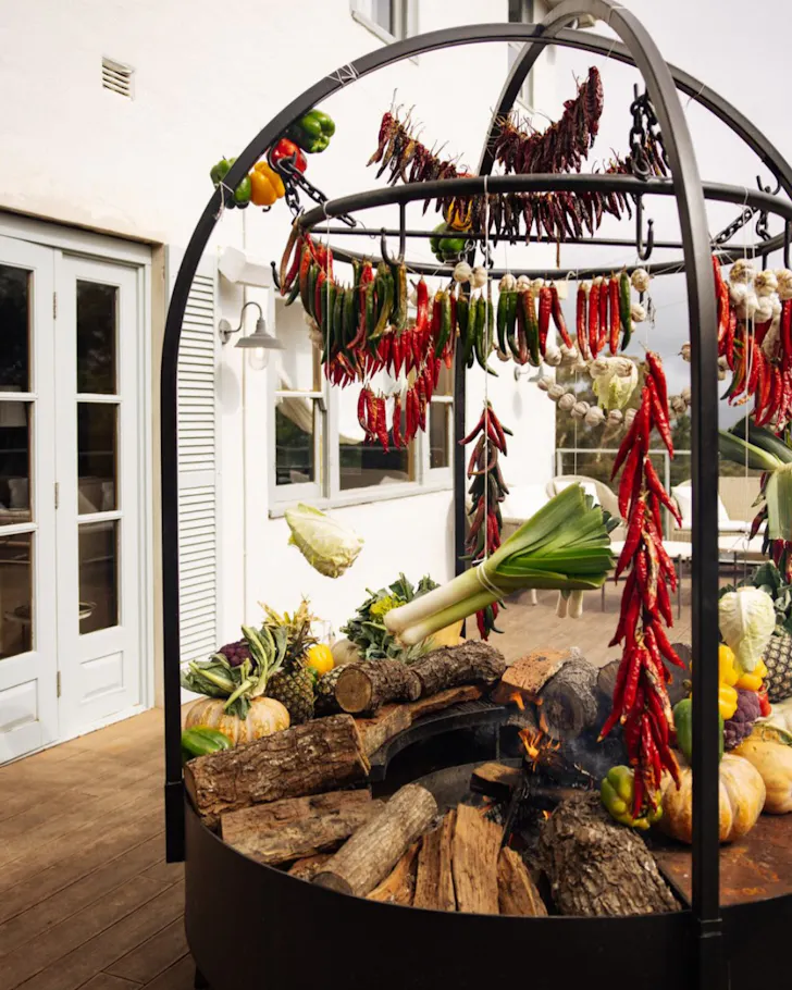 An open-flame kitchen cooks food in the courtyard at Fire Kitchen