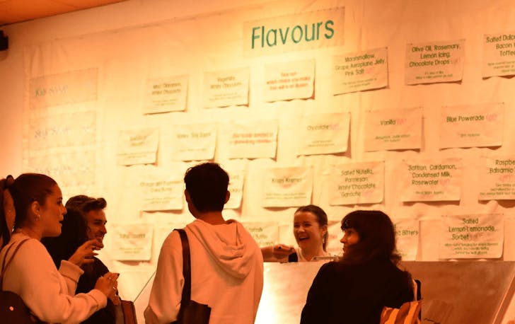 A group of people standing around a brick bar laughing at one of the best ice cream shops in Melbourne.