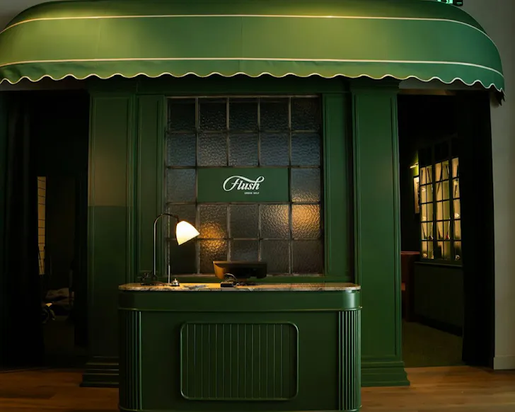 A chic green entranceway to an urban golf bar.