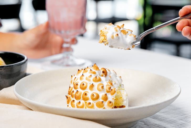 A meringue dessert is scooped onto a spoon.