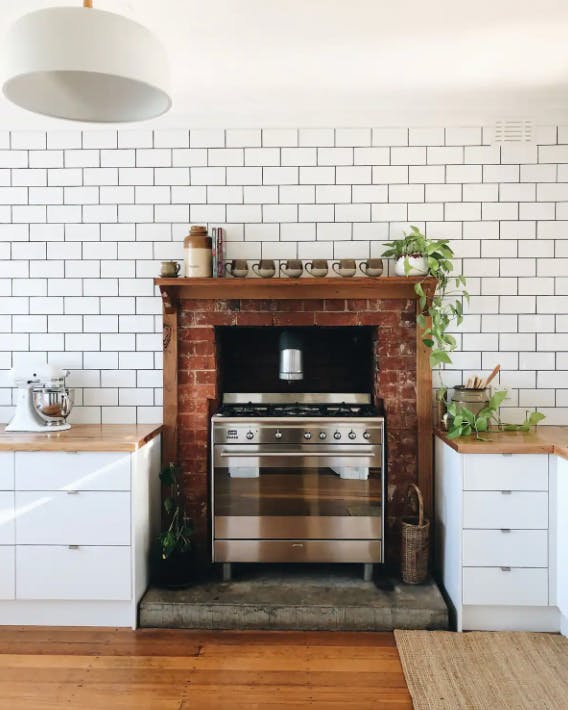 A white-tiled kitchen with a large brick oven and grill, a best Dandenong Ranges stay.