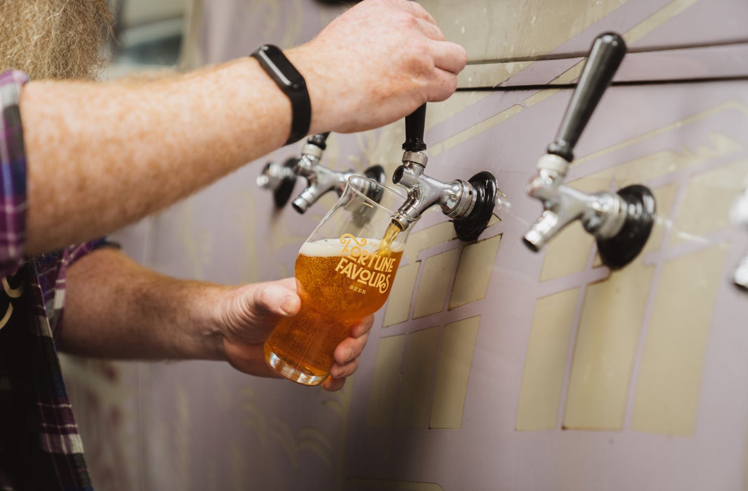 A man pouring a handle of beer