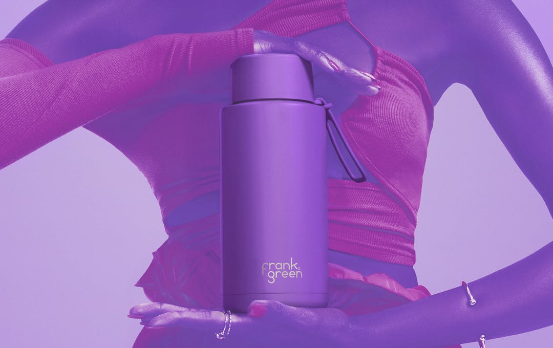 A person holding a purple drink bottle. 