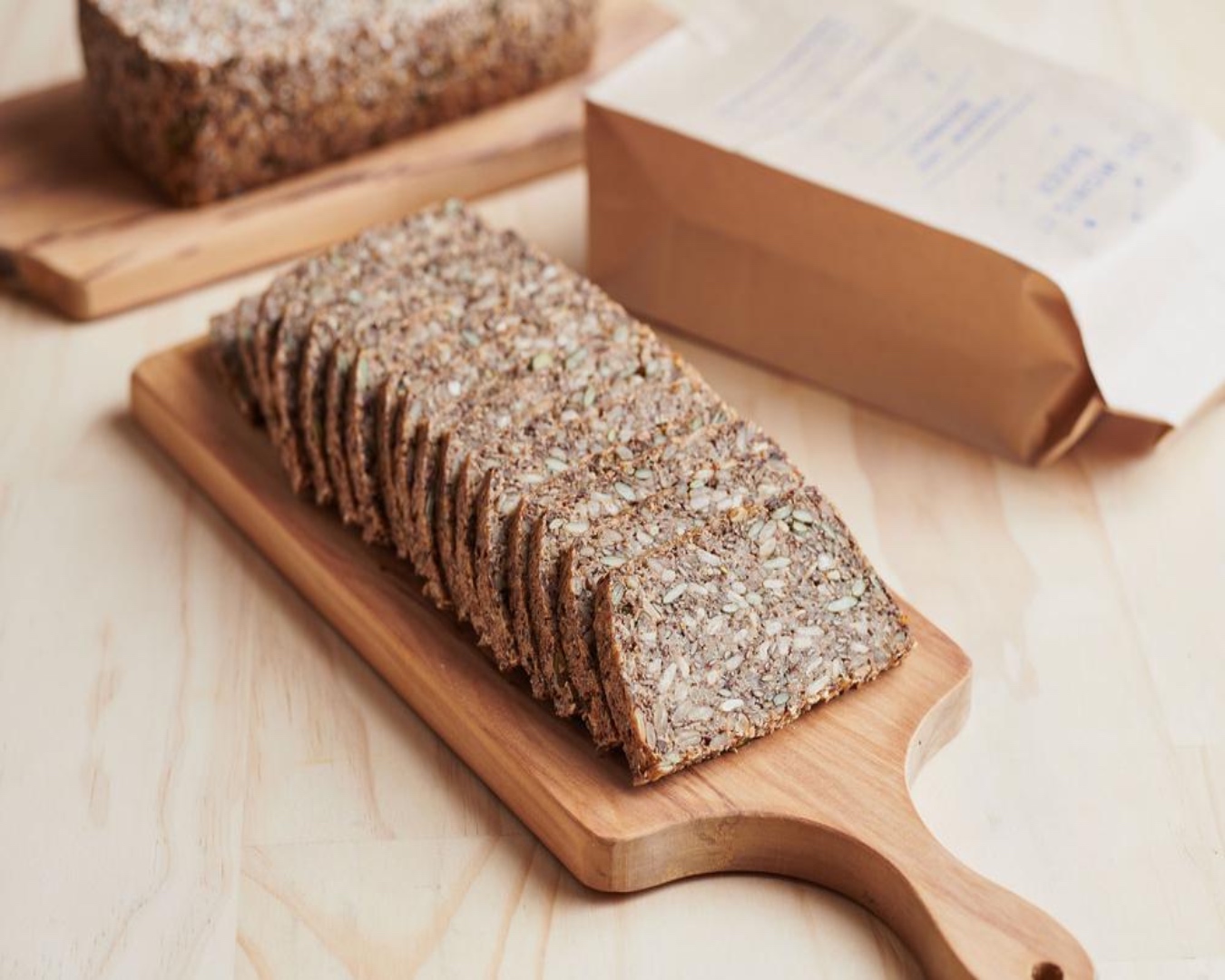 A sliced seeded bread sitting on a chopping board. 