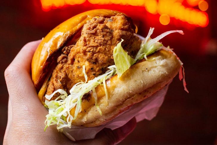 A hand grips a mighty looking chicken burger.