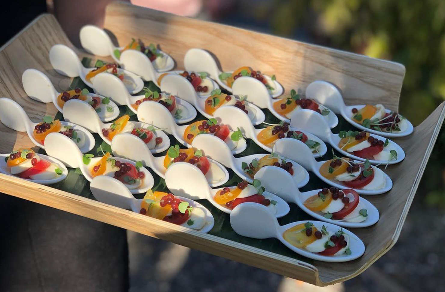 a platter full of spooned canapes