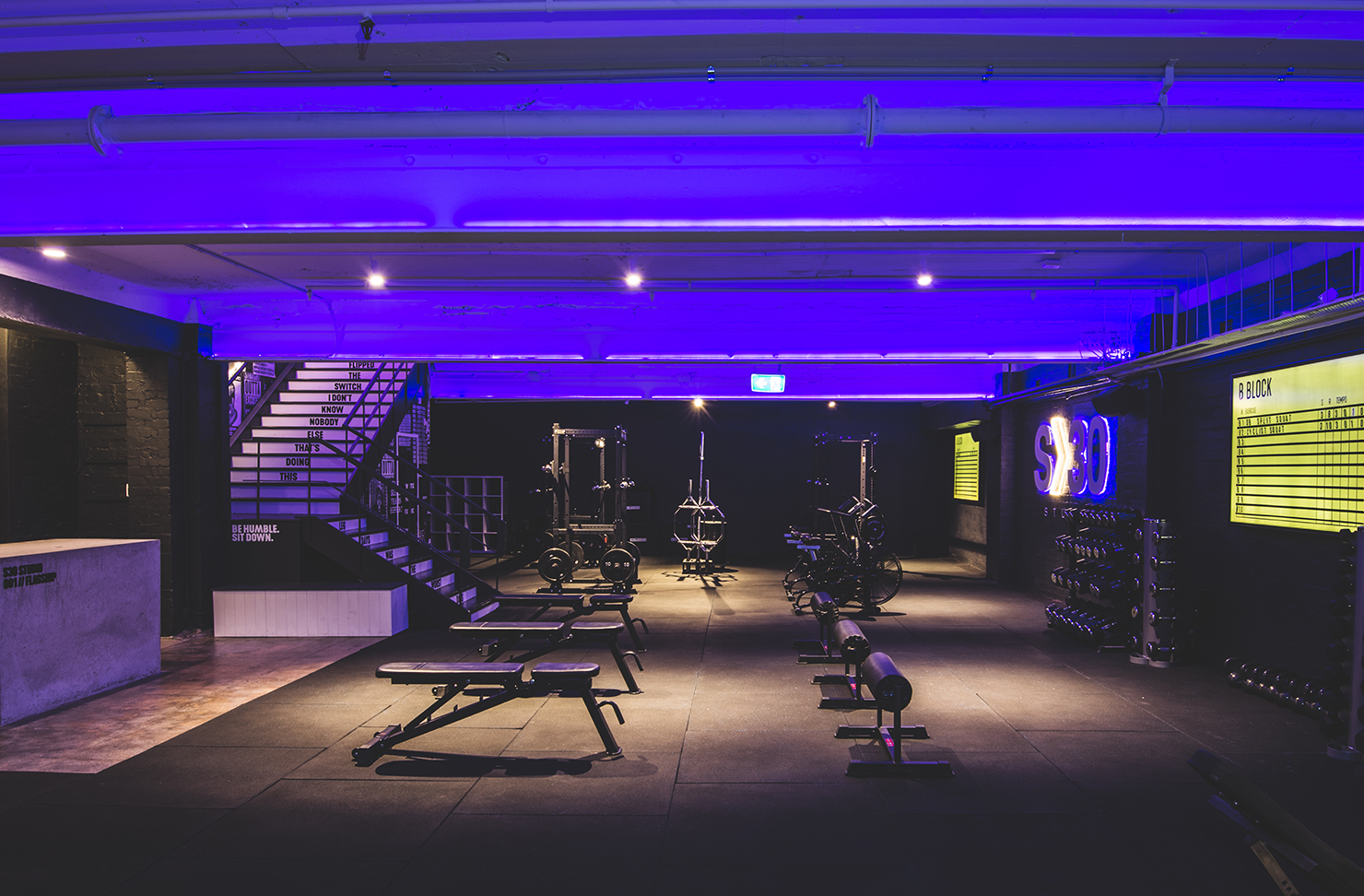 the interior of a dark, black and purple gym room
