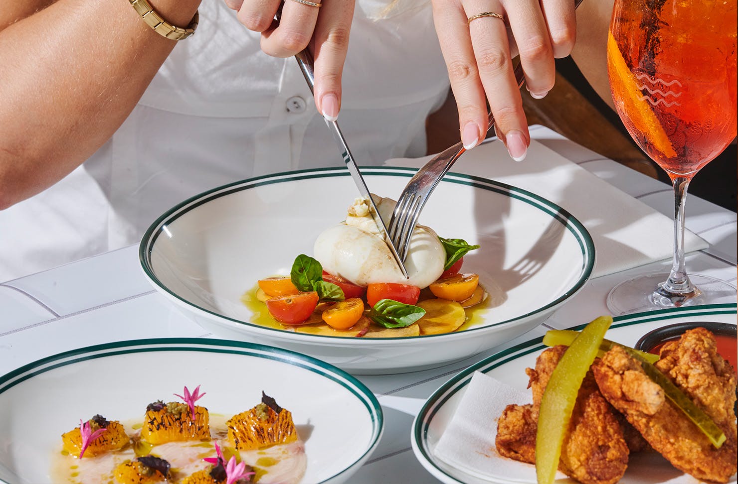 Three plates of food with aperol