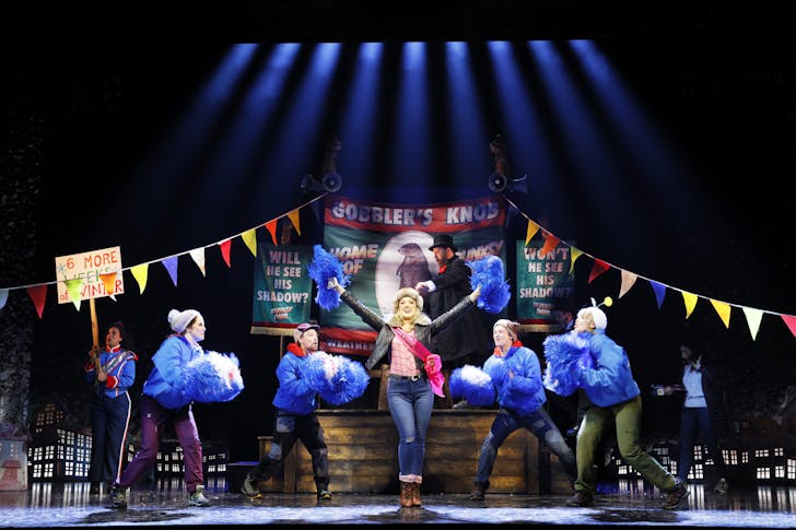 People dancing on theatre stage.