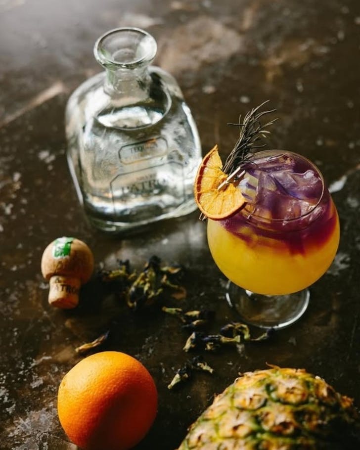 A bright yellow and purple tequila cocktail.