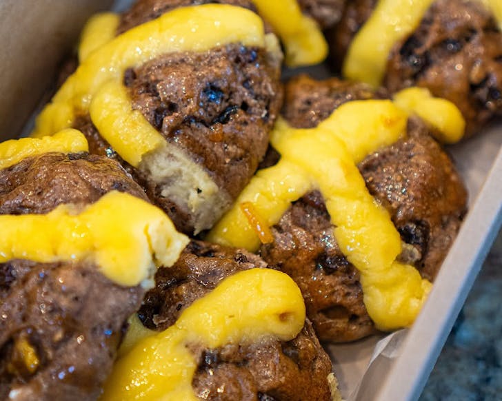 Plump, fruit-filled hot cross buns with thick yellow crosses. 
