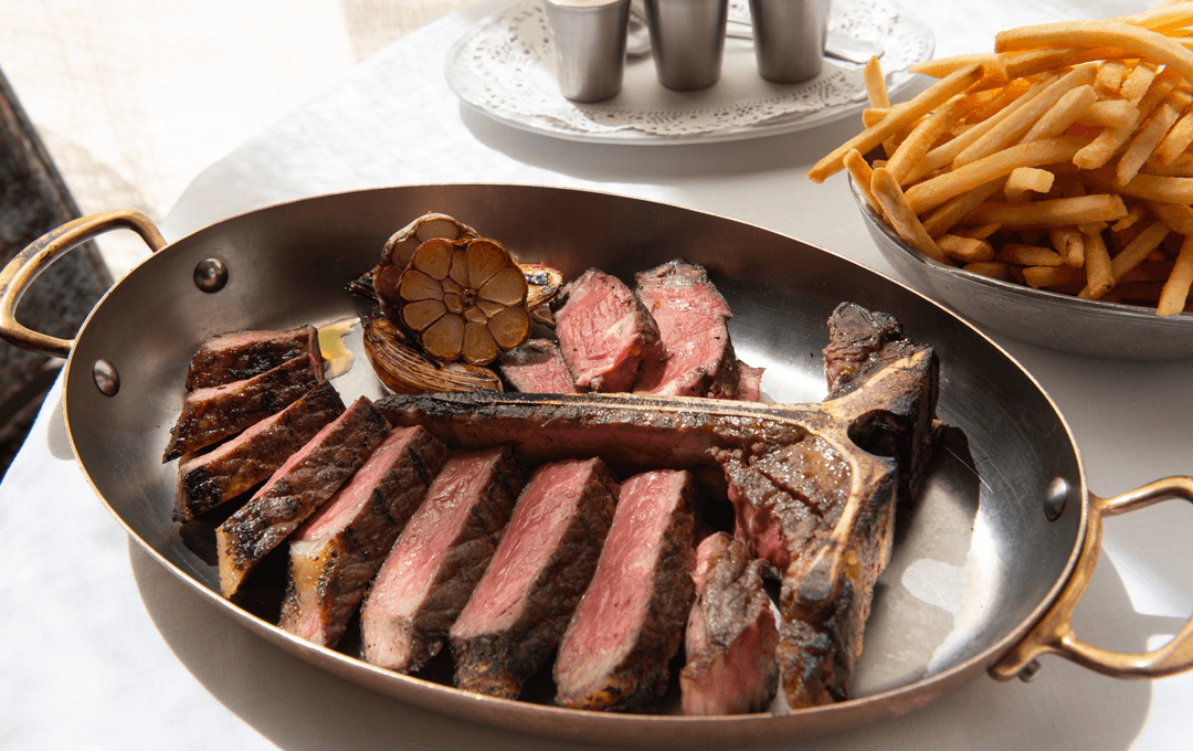 A metal serving platter with a perfectly sliced rib eye, one of the best steaks in Melbourne.