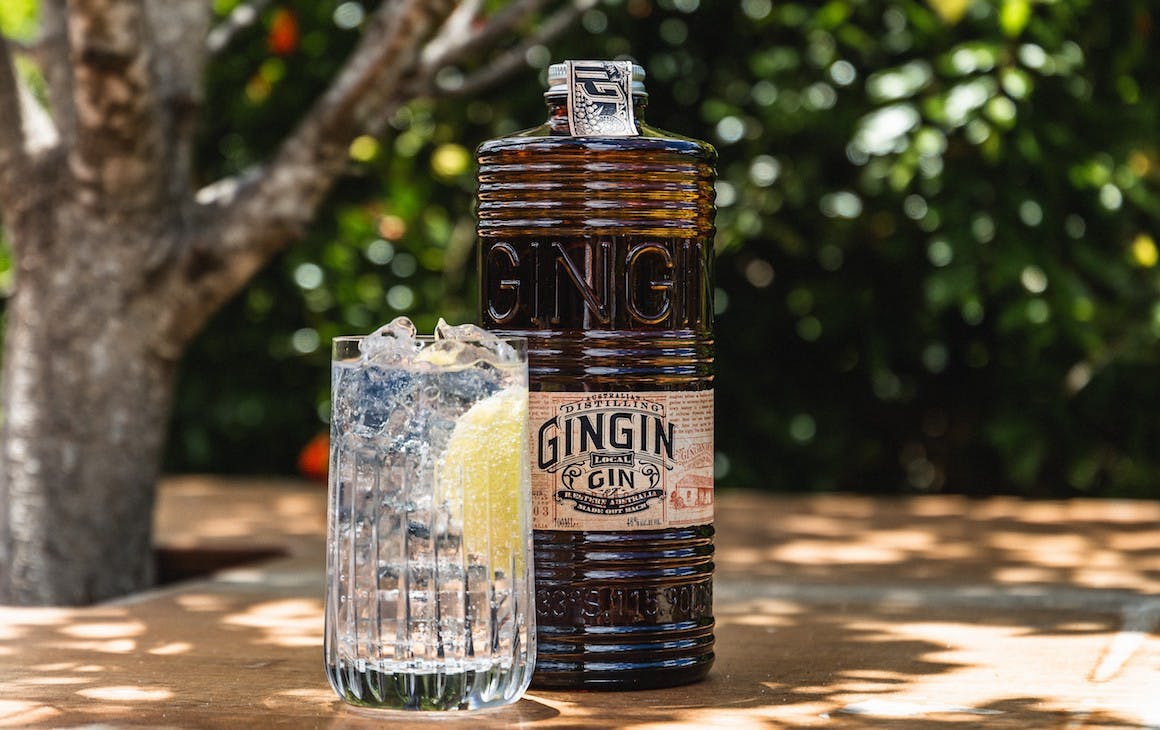 A bottle of Gingin gin next to a glass of gin and tonic