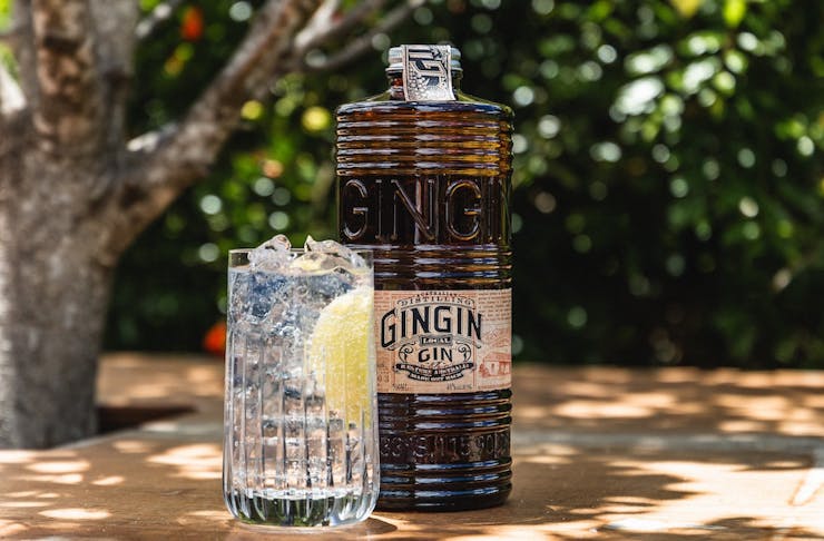 A bottle of Gingin gin next to a glass of gin and tonic