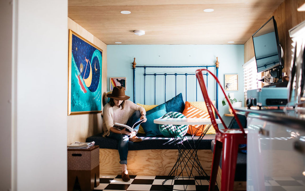 a guest sits on the day bed in a tiny home