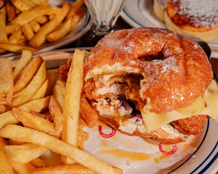 A glazed donut, cheese-stuffed fried chicken burger with fries. 