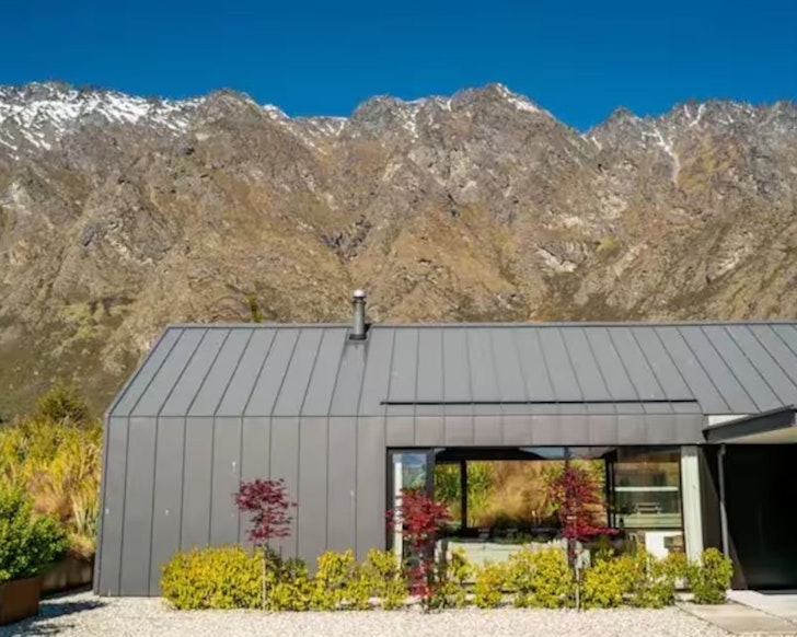 An exterior view of Glenfiddich Retreat with a mountain behind it, one of the best Airbnbs for large groups in Queenstown