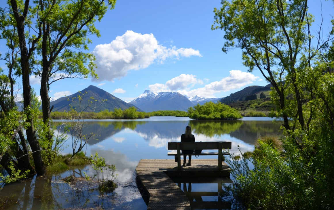 Someone sits on a peaceful bench looking out over a beautiful vista in Glenorchy.