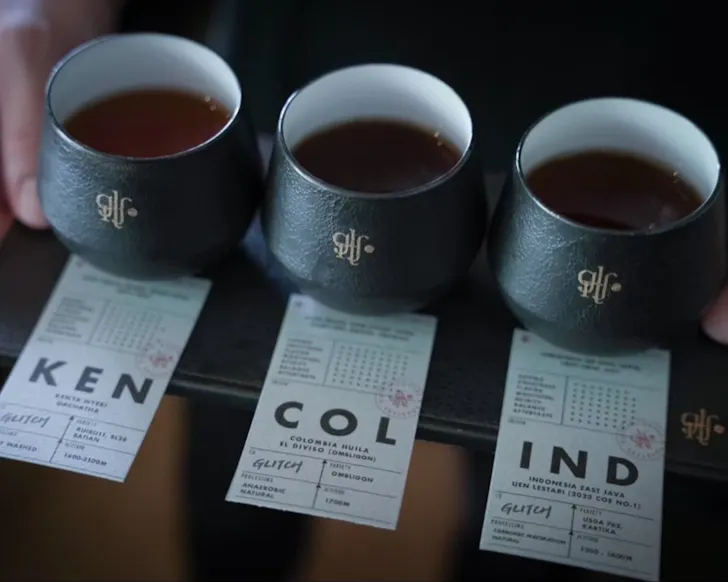 A trio of coffee cups complete with tasting notes at Glitch Coffee.