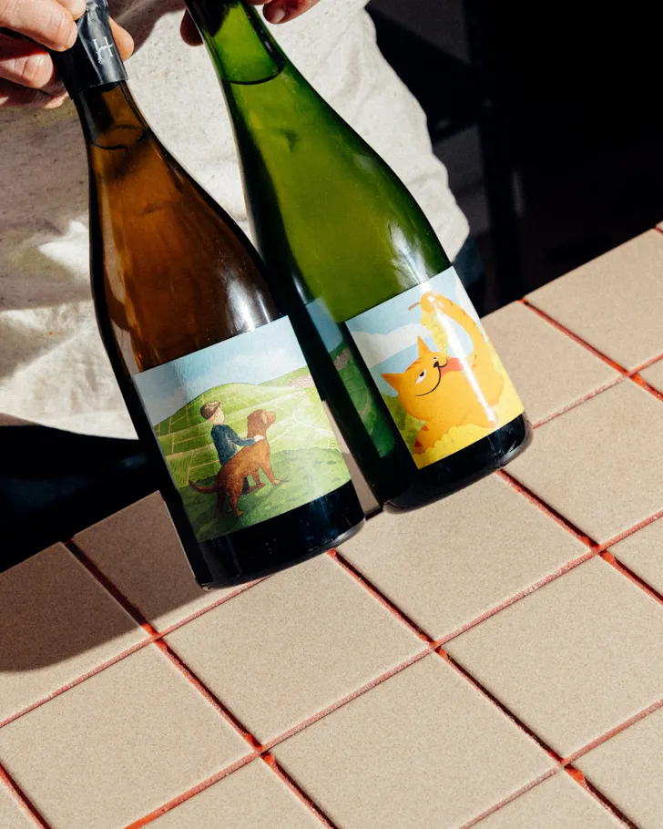 Two natural wines on the red-and-white benchtop at Glug.
