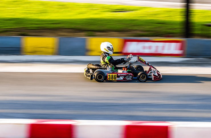 A person speeding past the frame in a go-kart. 