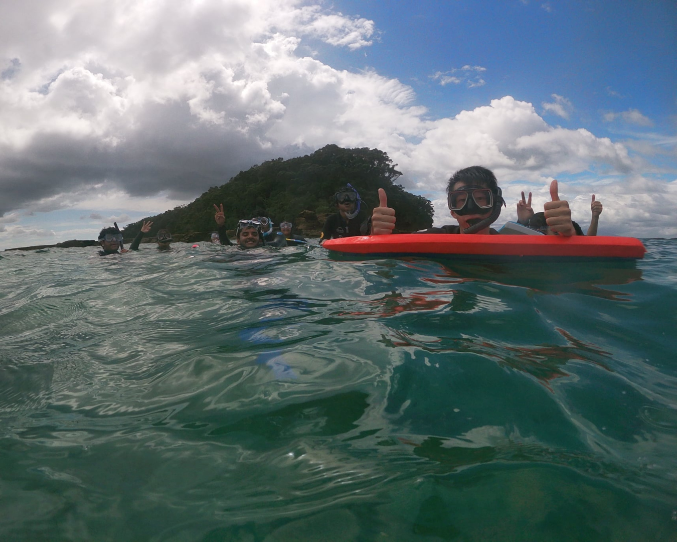 A group of kids give the thumbs up while snorkelling in the water at Goat Island Marine Reserve. 