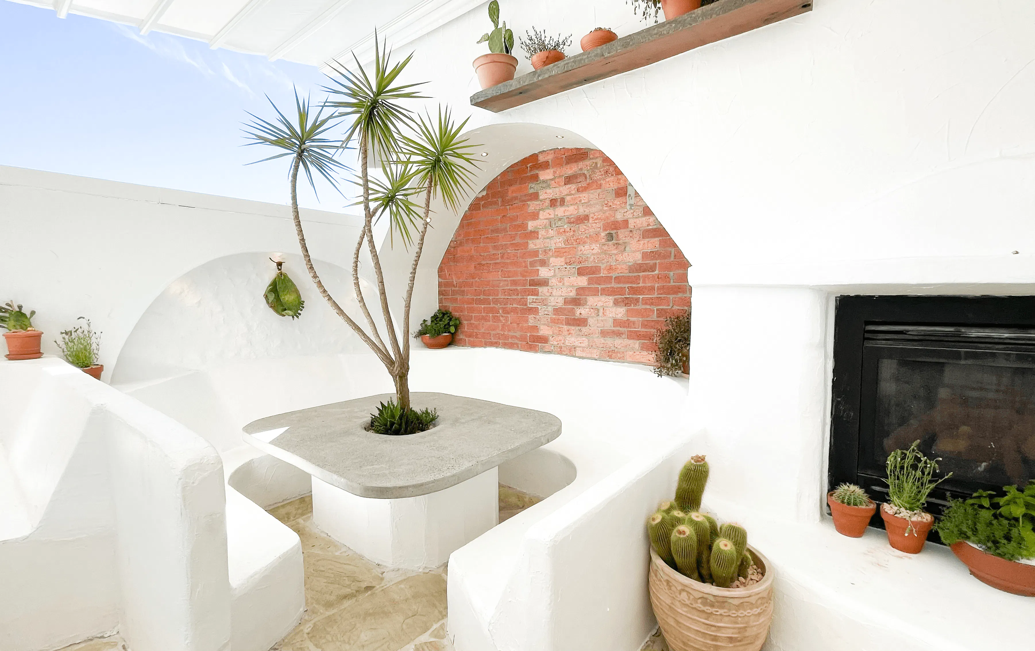 A rooftop with white brick booths and tables.