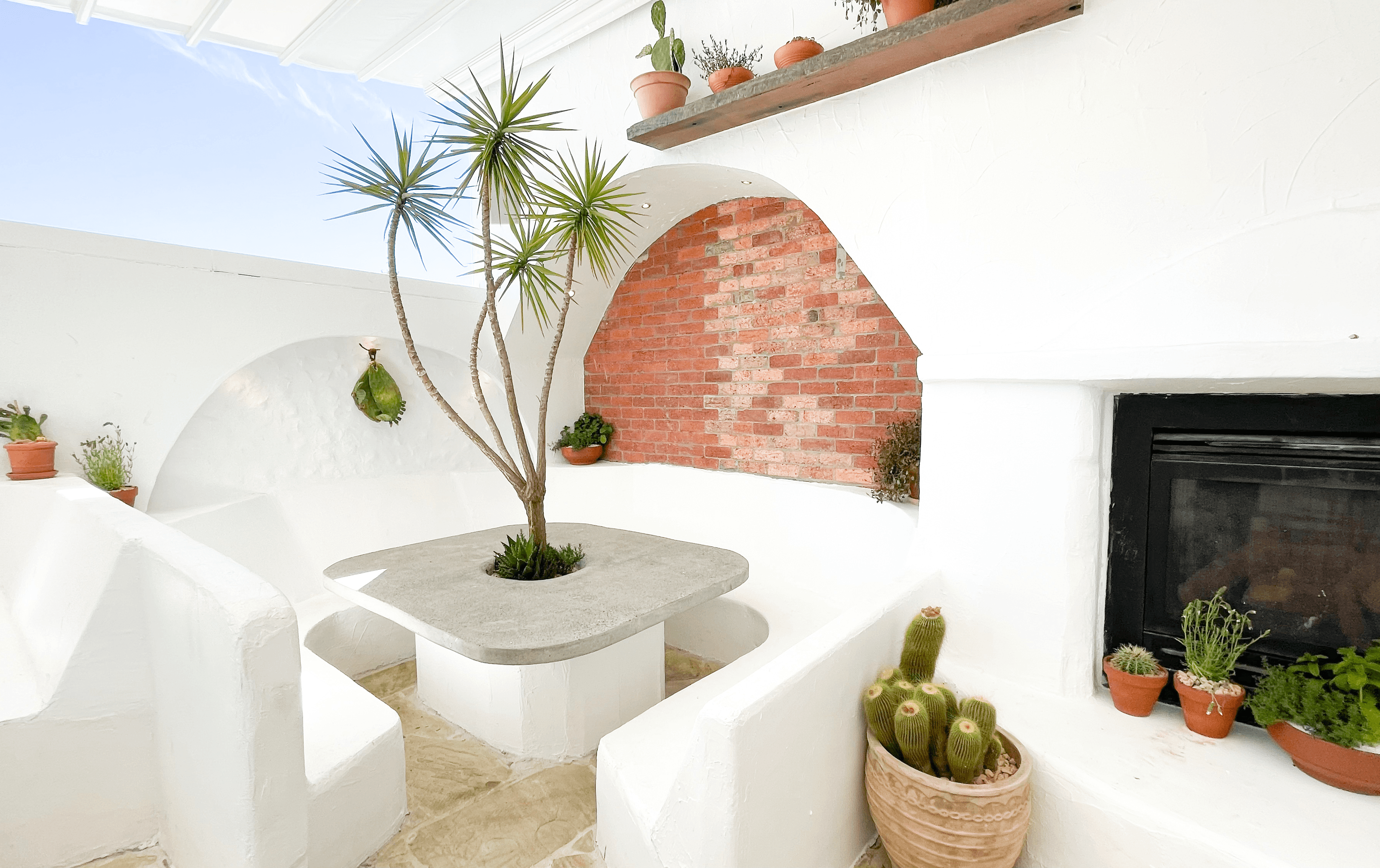 A rooftop with white brick booths and tables.