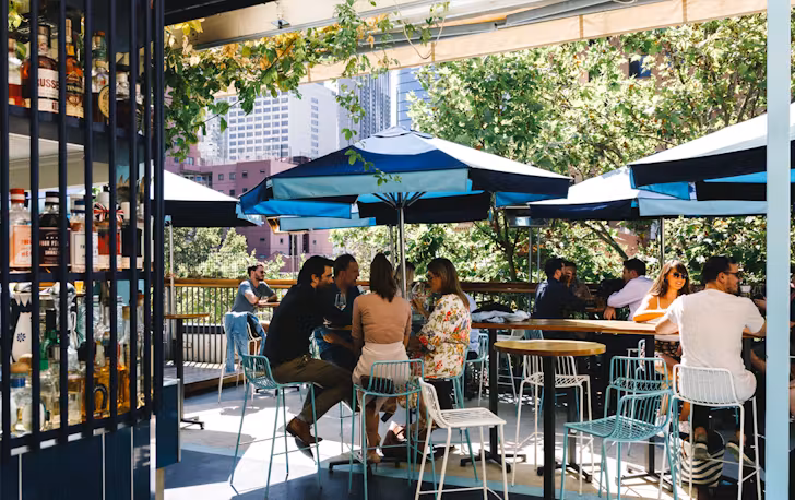 A rooftop with people drinking at one of the best cbd bars in Melbourne. 