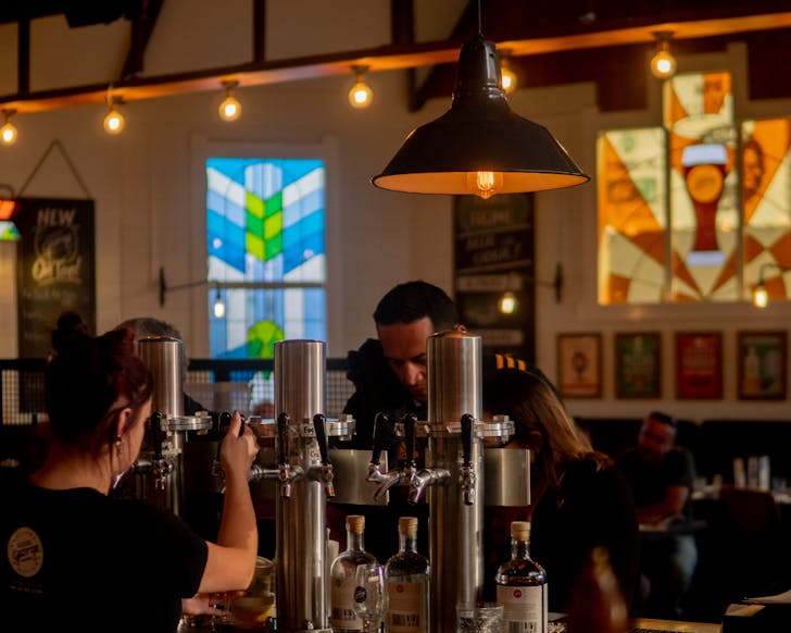 A person pours pints inside waht was a fromer church, and is now the Good George Dining Hall. 