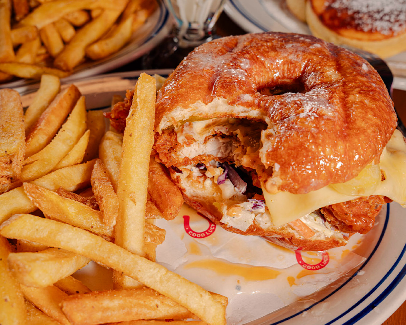 A glazed donut burger with a generous portion of fries. 