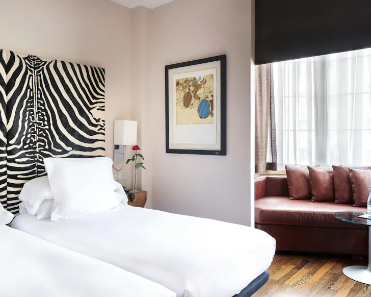 A unique, sunlit bedroom at Gran Derby Suite with a zebra-striped headboard.