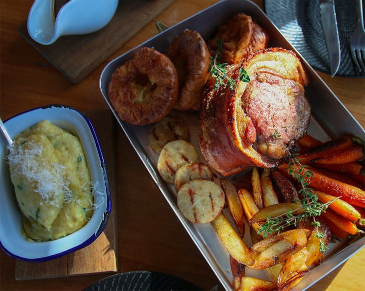 Roast pork belly in a dish with mashed potatoes on the side at Grangers.