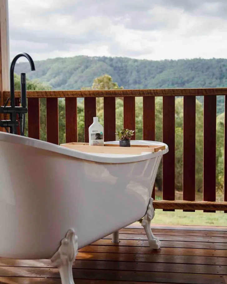 A view of the white clawfoot outdoor bath at Grey Gum Eco Luxury Cottage Airbnb near Brisbane, Queensland
