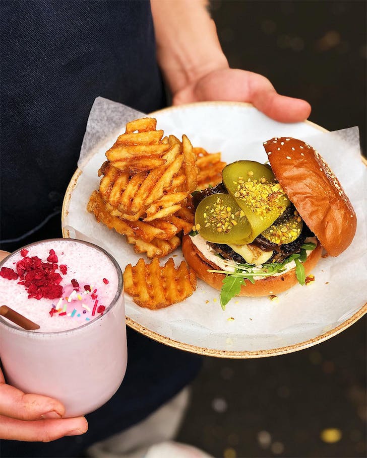 The Lam-burg-ini with Herby lamb paddy, gouda, onion jam, spiced yoghurt & waffle fries & Strawberry Milkshake At Grey Street Kitchen, one of the best cafes in Hamilton.